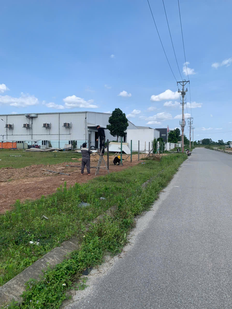 Đội ngũ công nhân thi công lắp dựng trụ thép và hàng rào tôn bảo vệ dự án 6ha Bình Xuyên